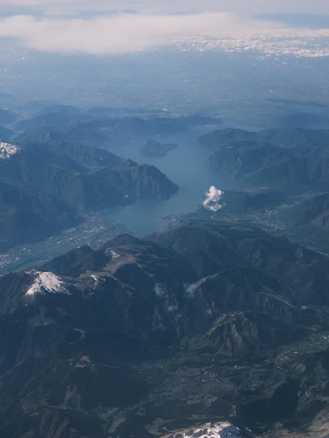 Mountain range and an alpine lake seen from an airplane window